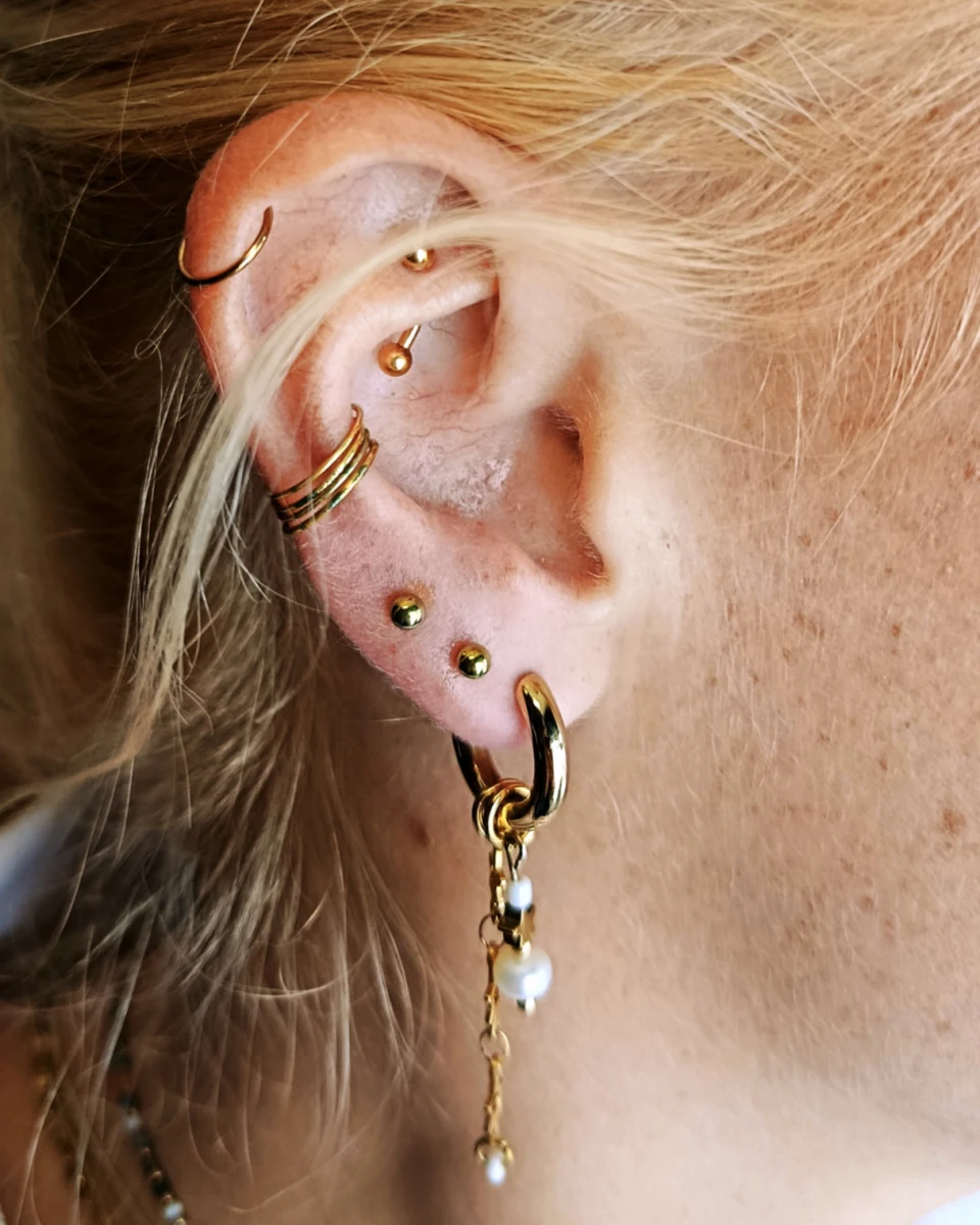 Composition d’oreille avec piercings helix, conch et lobes — Elyx